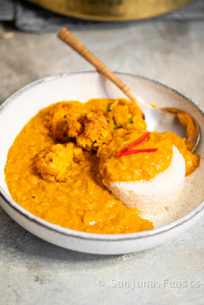 A bowl of lentil curry with a small mound of white rice